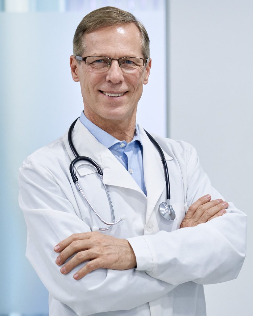 smiling-mature-senior-doctor-physician-standing-in-9AR35UM.jpg